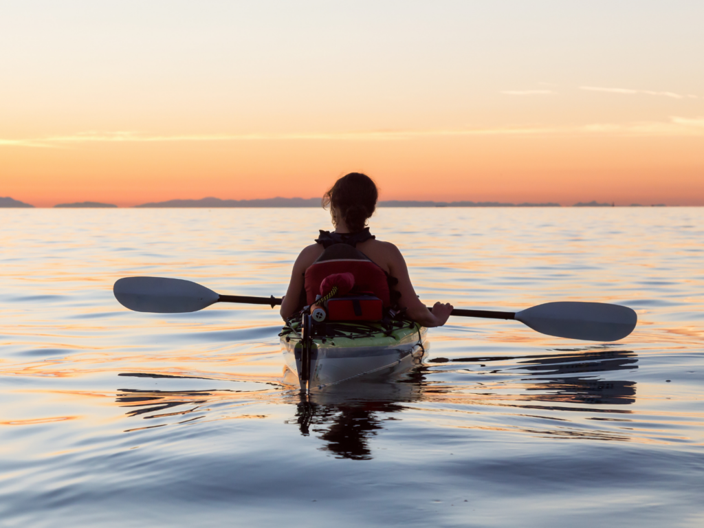charleston-sc-kayaking woman in kayak on he water watching sunset