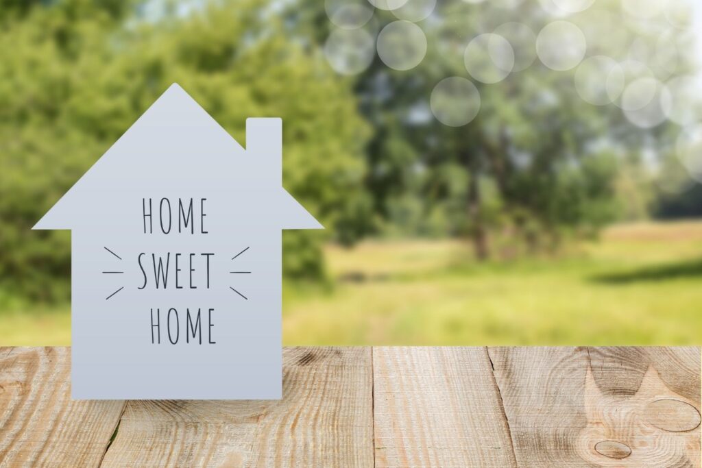 A cardboard cutout of a home with text reading "HOME SWEET HOME"