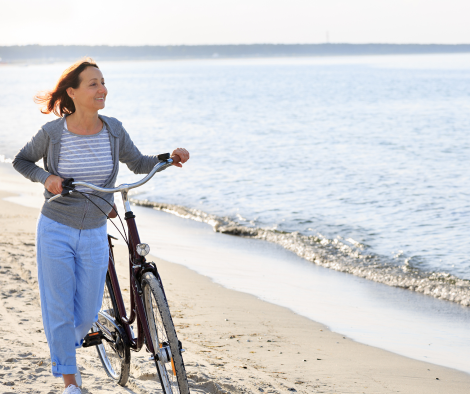 Woman with bike on beach. 