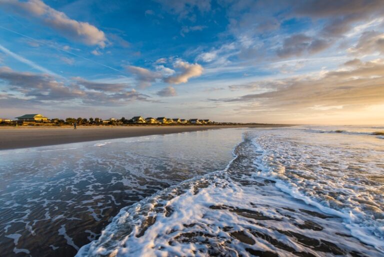 A stunning view of Isle of Palms from the shoreline at dusk as waves gently retreat back to the ocean inlet.