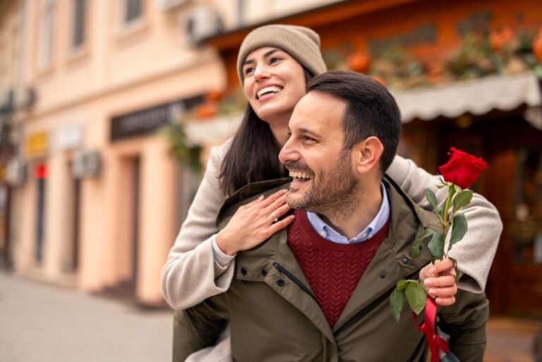 Romantic Things to Do in Charleston: A young woman smiles as she rides piggy back upon her male partner.