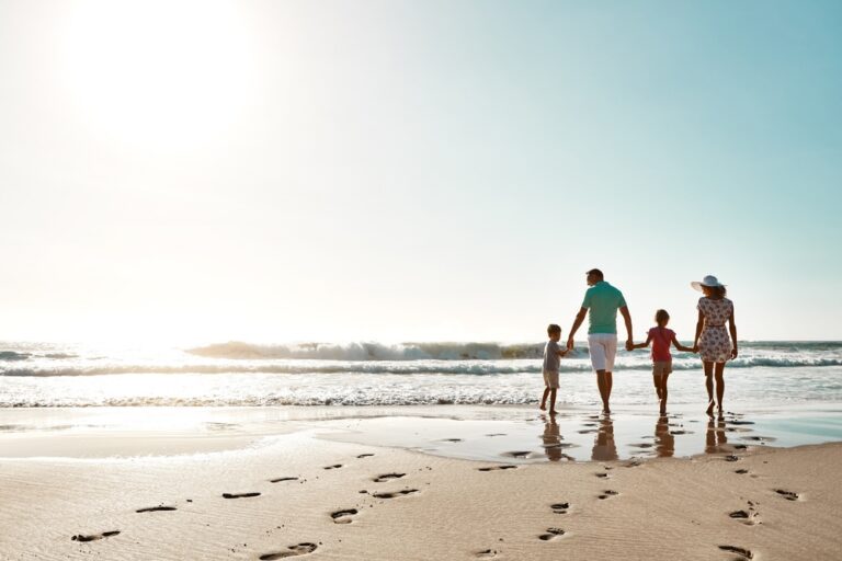 Fun things to do in Charleston: Family holding hands on the beach