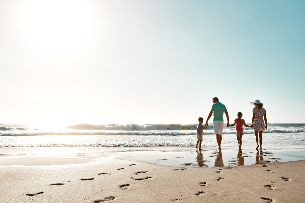 Fun things to do in Charleston: Family holding hands on the beach